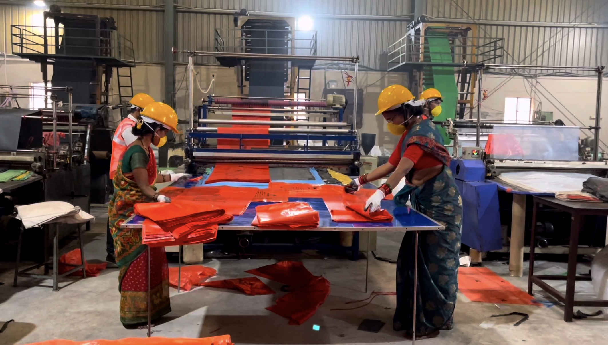 Workers folding biomedical red bags at Ushakiran Ecoplast facility
